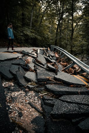 Photo of a broken road  and the aftermath of an earthquake.