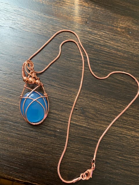 Image of copper wire wrapped necklace with blue jewel.
