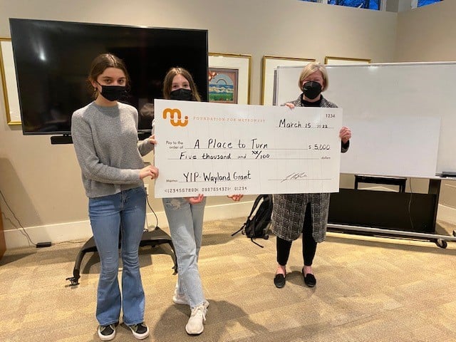 3 masked people hold a large check, made out to "A Place to Turn" from the Foundation for MetroWest, dated March 15, 2022.