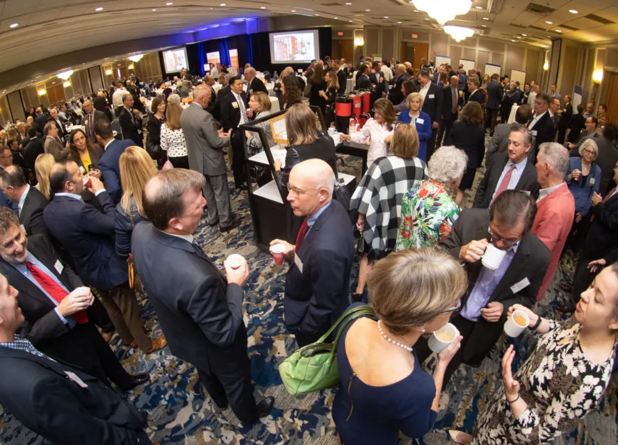 Overhead photo of a large group of people socializing in a formal setting.