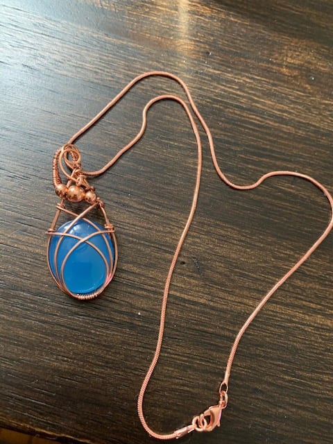 Image of copper wire wrapped necklace with blue jewel.
